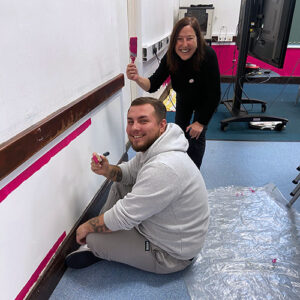 Two OneFamily colleagues painting