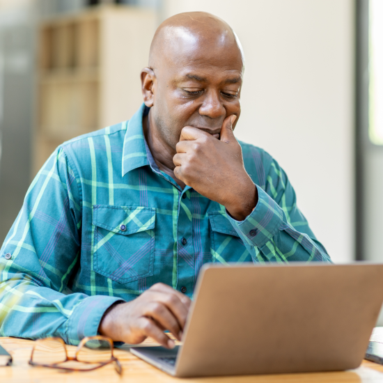 Man looking concerned with open laptop in front of him