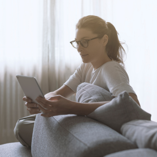 Woman sat on a sofa using a laptop